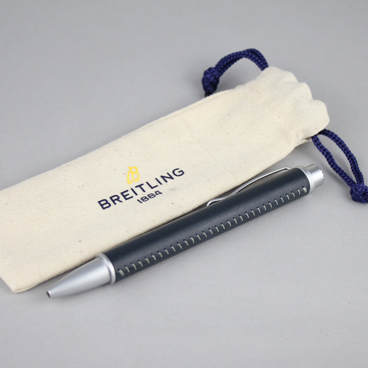 blue Breitling pen aside of white Canvas Breitling pen storage bag.