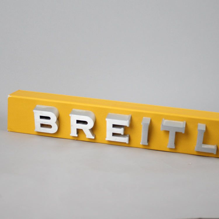 Used Breitling sign with yellow backround.