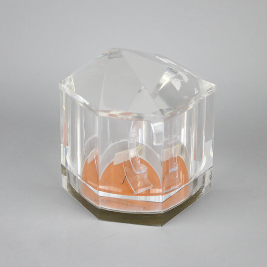 Closed vintage Omega watch stand which is made to resemble the quartz crystal of a quartz movement.