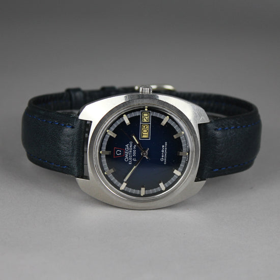 Omega electronic geneve chronometer with deep blue dial and steel case on table.